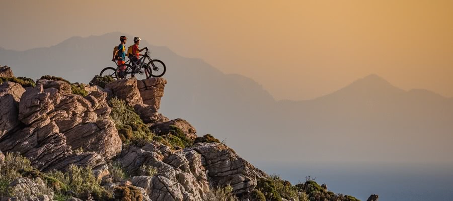 Zwei Mountainbiker auf einem Felsen in der Abendsonne, Türkei