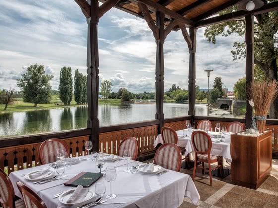 Terrasse mit gedeckten Tischen und Blick auf den Fluss