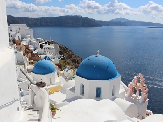 Blaue Kuppelkirchen auf den Klippen von Santorin mit Blick auf das Meer