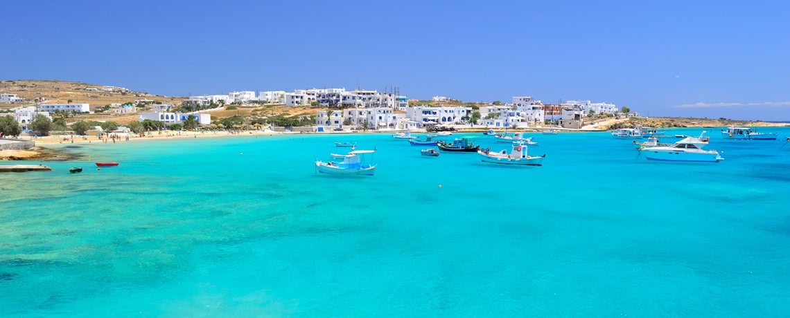 Fischerboote im türkisen Wasser vor griechischer Insel