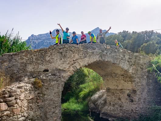 Radreisegruppe auf Brücke macht Gruppenfoto