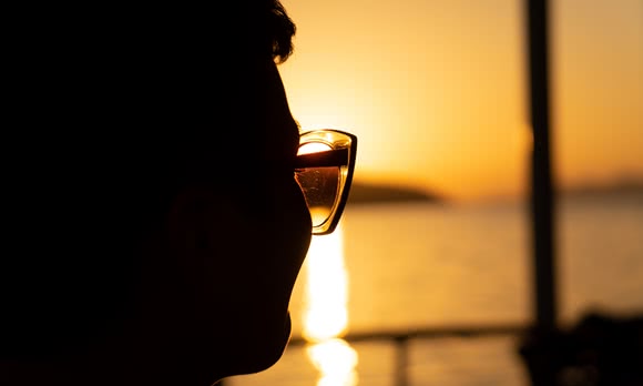 A part of a woman's face looks into the sunset