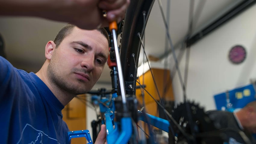 Mann mit Werkzeug repariert Fahrrad