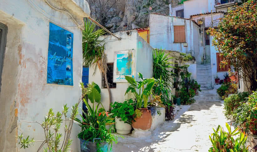 Alleyway with white washed houses and blue sign