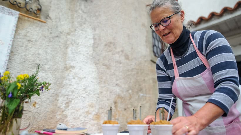 Frau steht an einem Tisch mit kleinen Töpfen mit Eiscreme